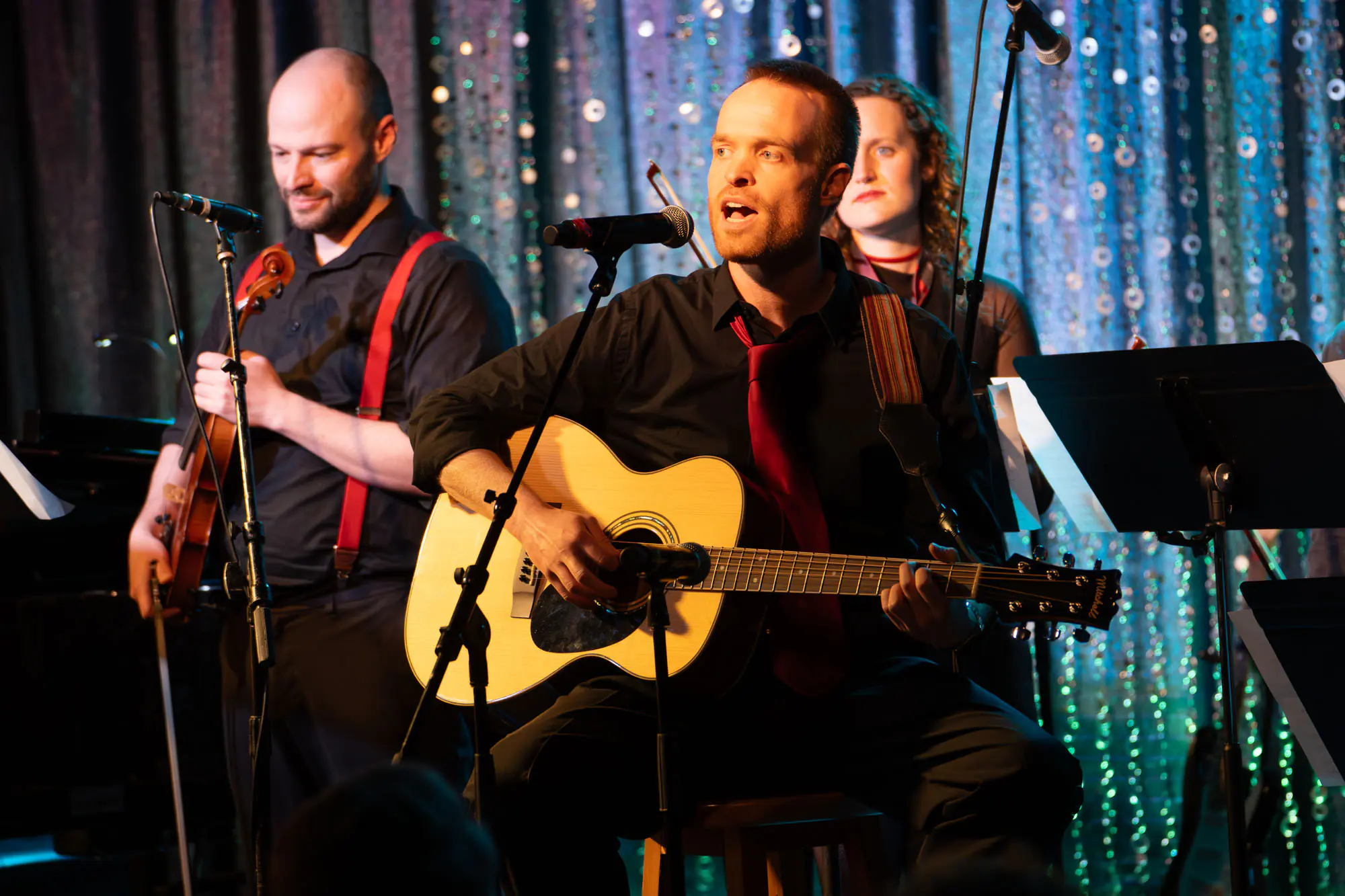 A man singing while playing guitar